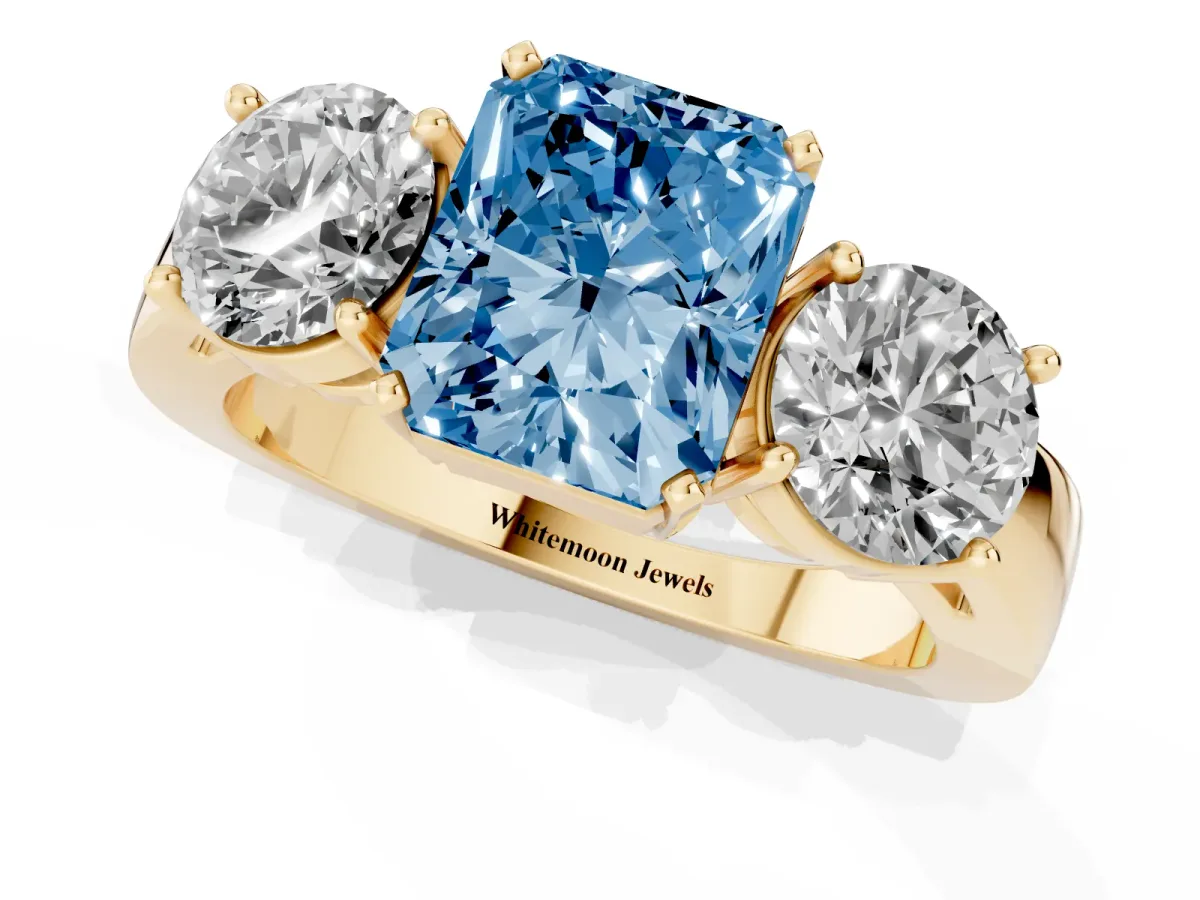 Fancy Blue Three-Stone Radiant Cut Diamond Ring with Round Side Stones, Classic Band, and Four-Prong Setting Yellow gold