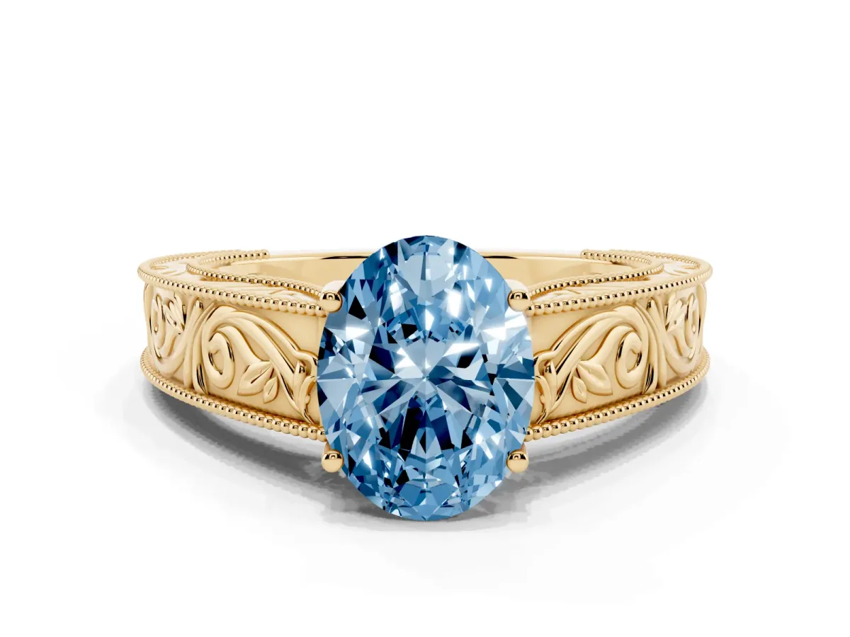 Fancy Blue Oval Cut Diamond Solitaire Ring with Engraved Band and Four-Prong Setting Yellow gold