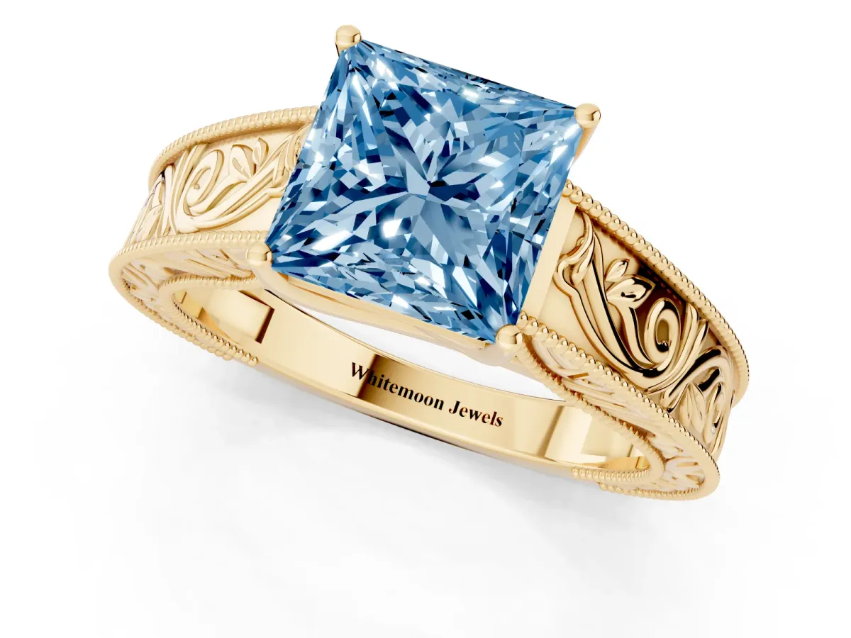 Fancy Blue Princess Cut Diamond Solitaire Ring with Engraved Band and Four-Prong Setting Yellow gold
