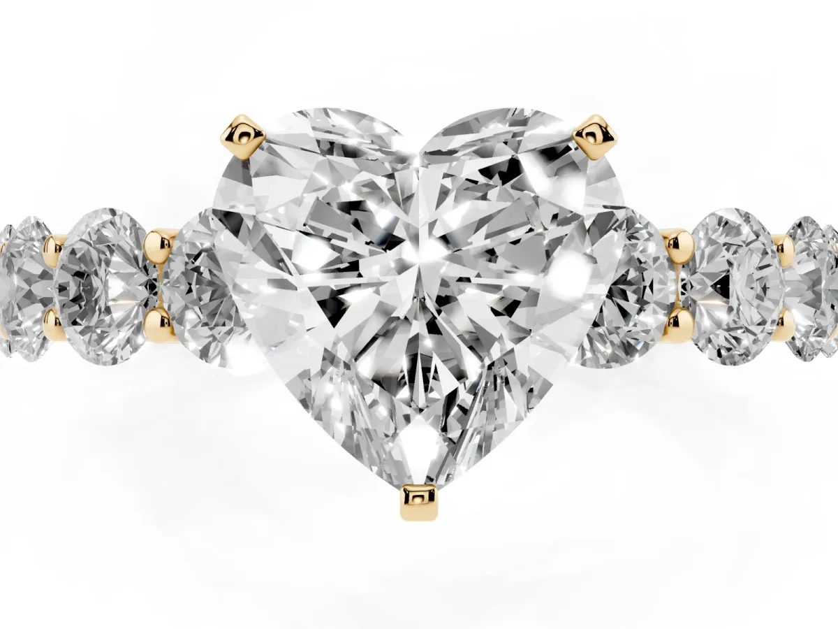 Heart Cut Diamond Prong Setting with Side Stones on a Pave Band Yellow gold