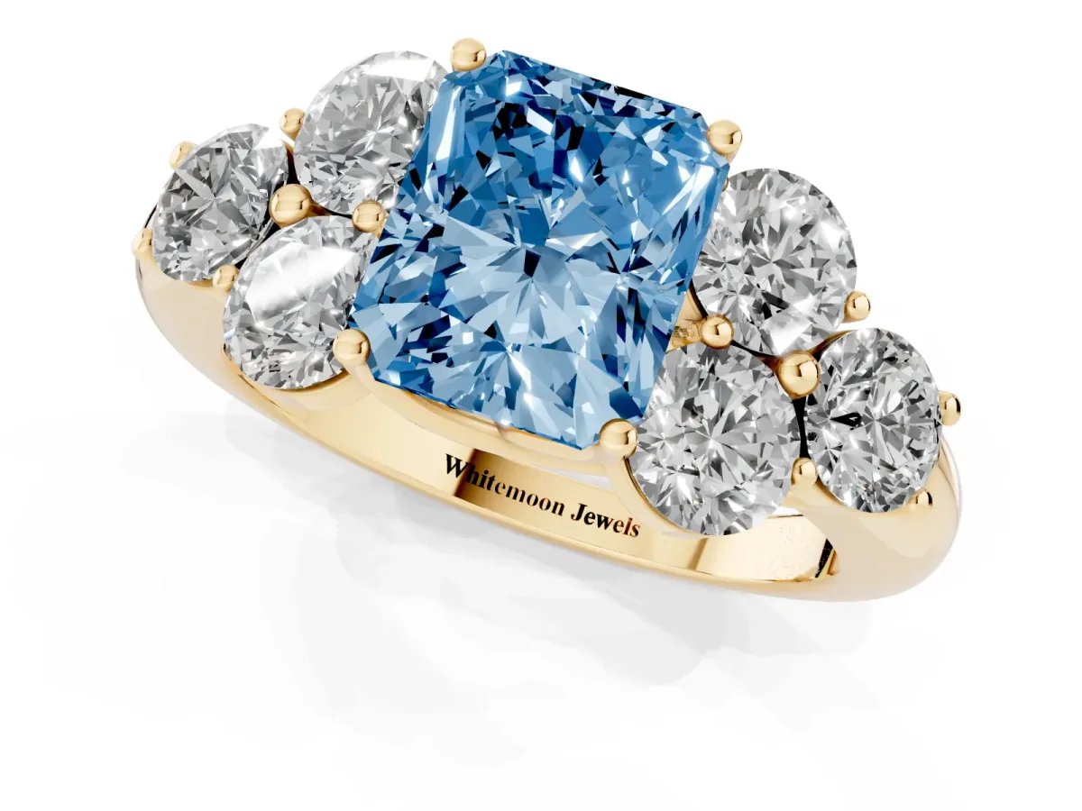 Fancy Blue Radiant Cut Cut Diamond Cluster Ring with Round Accent Stones and Prong Setting on a Classic Band Yellow gold