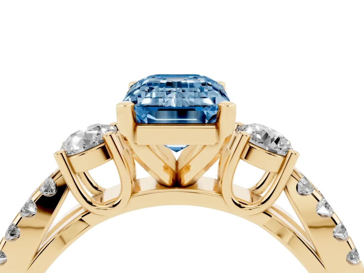 Fancy Blue Emerald Cut Diamond Three-Stone Ring with Pavé Split Shank and Four-Prong Setting Yellow gold