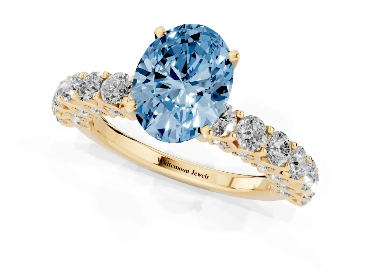 Fancy Blue Oval Cut Diamond Solitaire Ring with Shared Prong Pavé Band and Four-Prong Setting Yellow gold