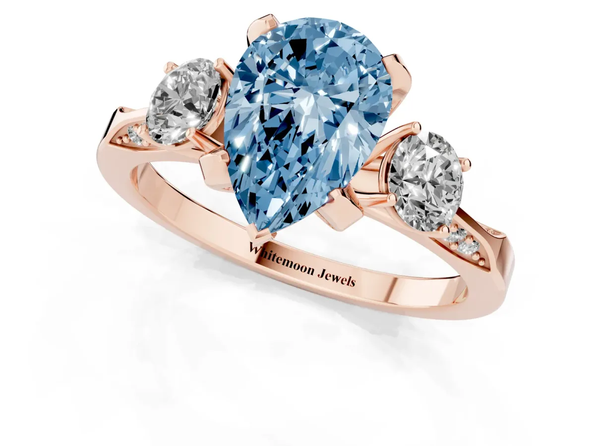Fancy Blue Pear Cut Brilliant Three-Stone Diamond Ring with Pavé Band and Four-Prong Setting Rose gold