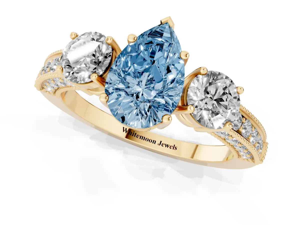 Fancy Blue Pear Cut Three-Stone Diamond Ring with Pavé Band and Four-Prong Setting Yellow gold