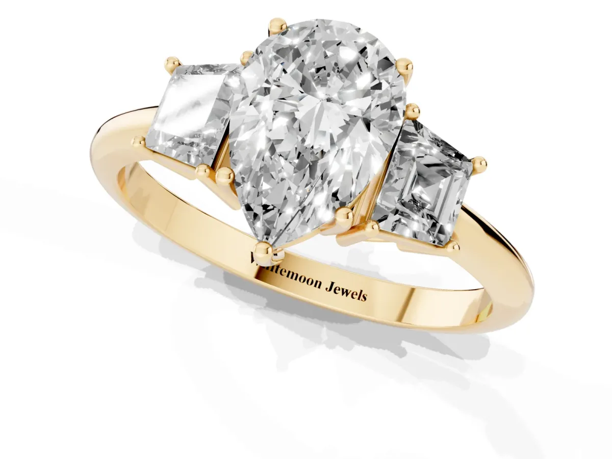 Pear Cut Diamond Three-Stone Ring with Trapezoid Side Stones and Prong Setting Yellow gold