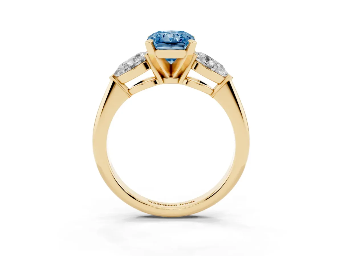 Fancy Blue Three-Stone Radiant Cut Diamond Ring with Pear Side Stones and Four-Prong Setting Yellow gold