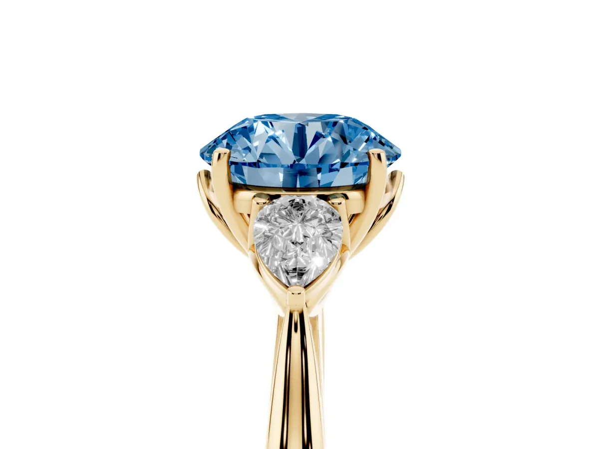 Fancy Blue Three-Stone Round Cut Diamond Ring with Pear Side Stones in Four-Prong Setting Yellow gold