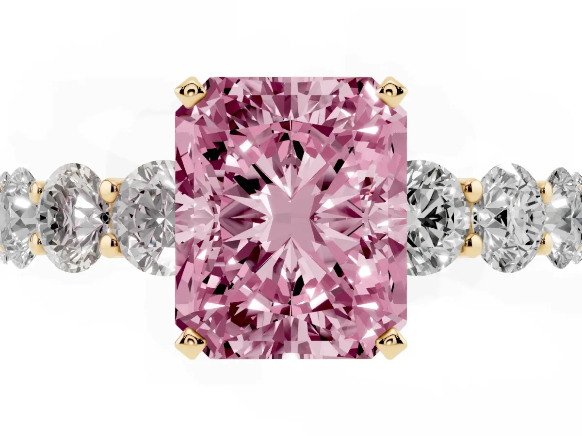 Fancy Pink Radiant Cut Diamond Prong Setting with Side Stones on a Pave Band Yellow gold