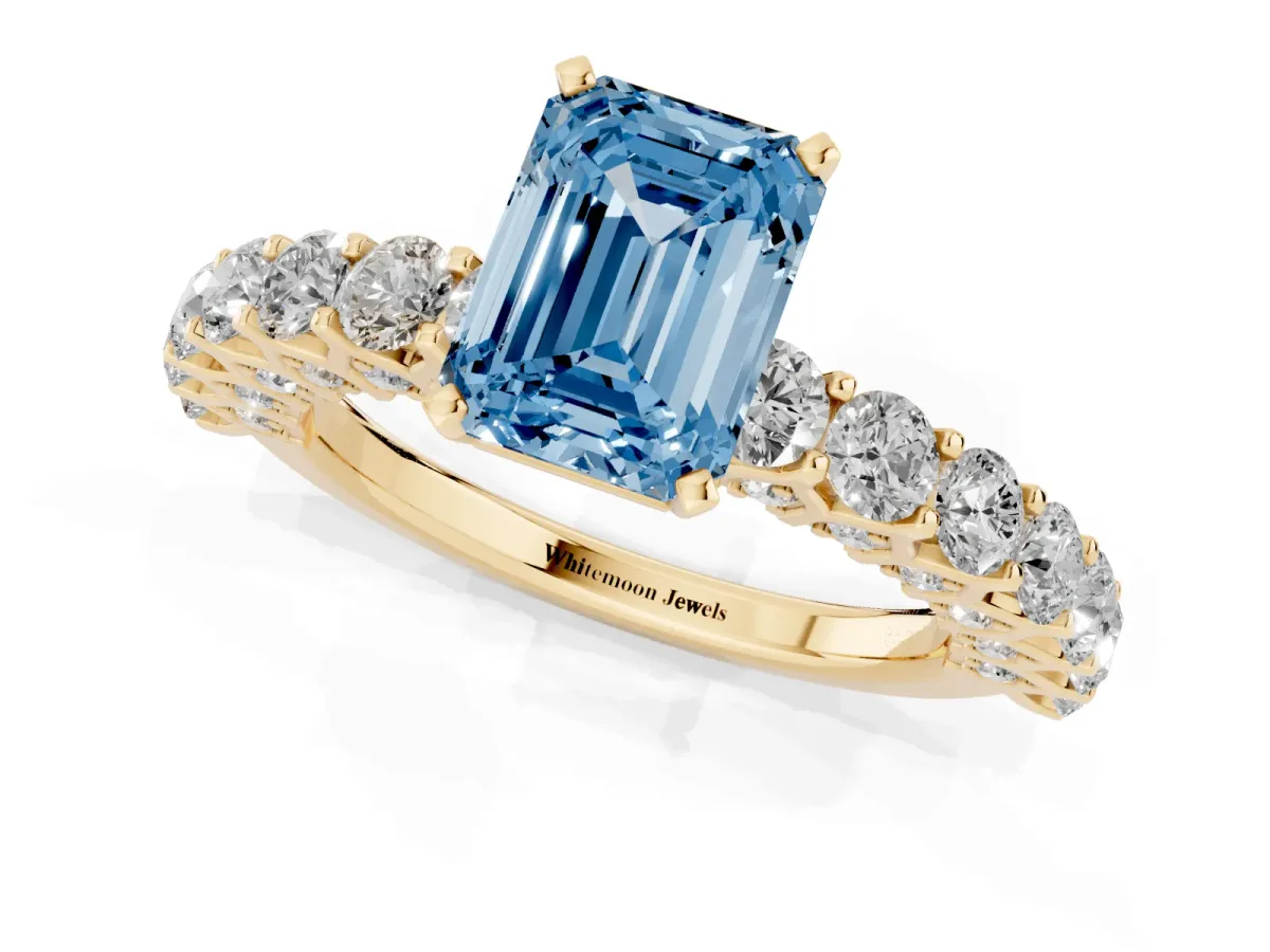 Fancy Blue Emerald Cut Diamond Solitaire Ring with Shared Prong Pavé Band and Four-Prong Setting Yellow gold