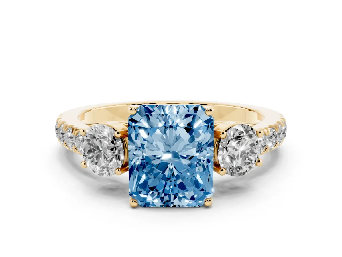 Fancy Blue Radiant Cut Cut Diamond Three-Stone Ring with Round Side Stones and Pavé Band Yellow gold