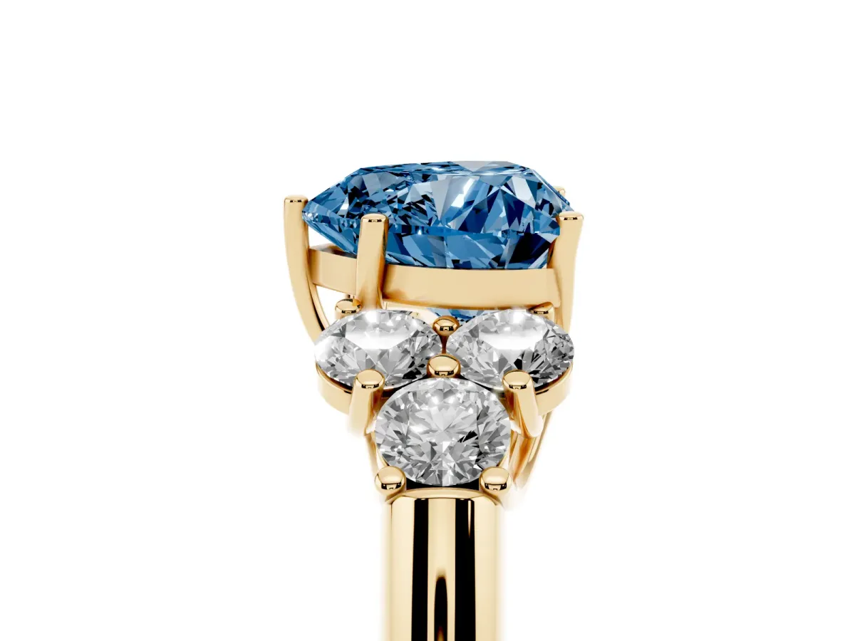 Fancy Blue Heart Cut Cut Diamond Cluster Ring with Round Accent Stones and Prong Setting on a Classic Band Yellow gold