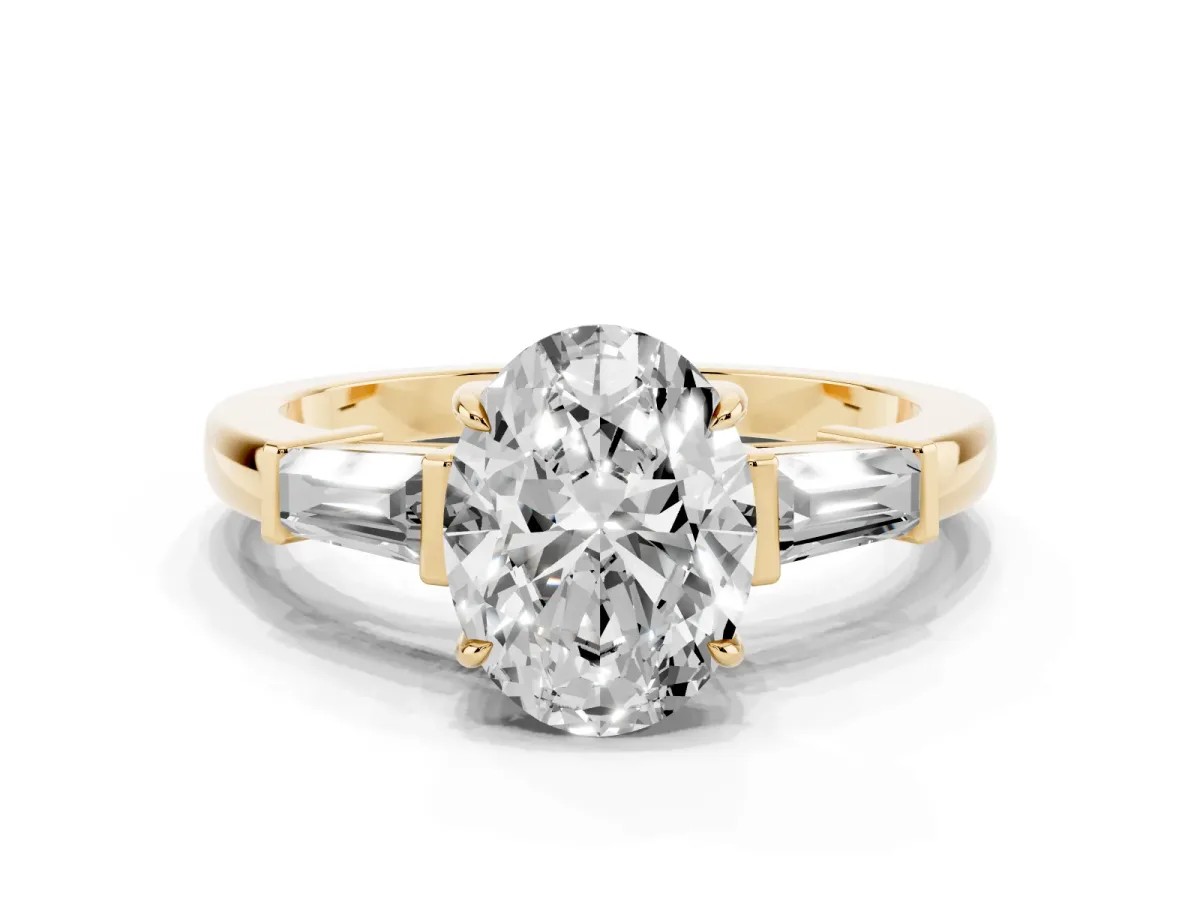 Oval Cut Diamond Three-Stone Ring with Tapered Baguette Side Stones and Prong Setting Yellow gold