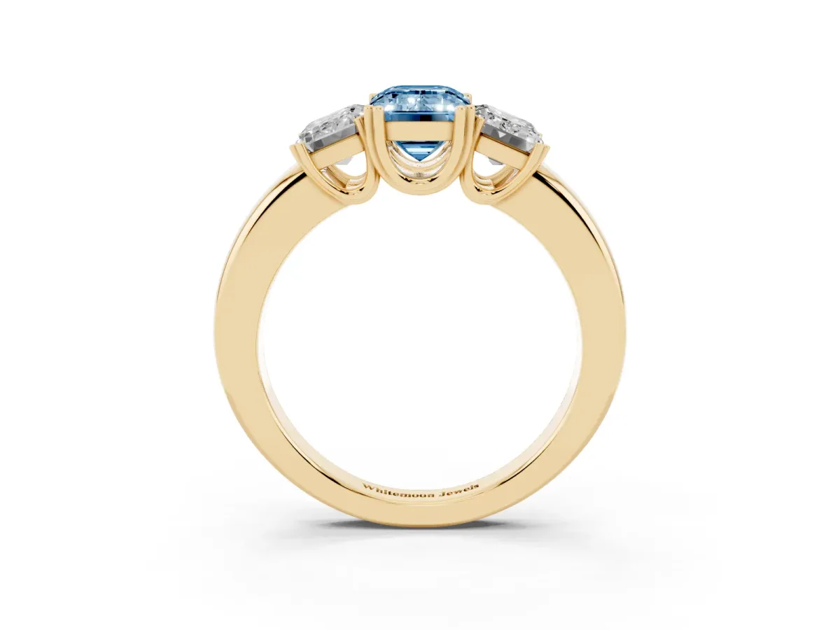 Fancy Blue Three-Stone Emerald Cut Cut Diamond Ring with Channel Set Band and Four-Prong Setting Yellow gold