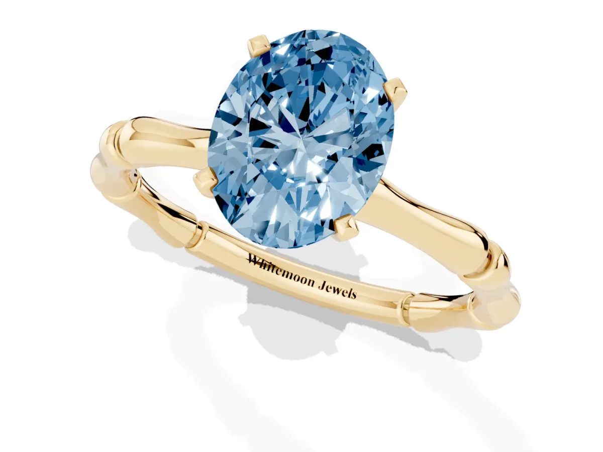 Fancy Blue Oval Cut Solitaire Diamond Ring with Bamboo Band and Four-Prong Setting Yellow gold