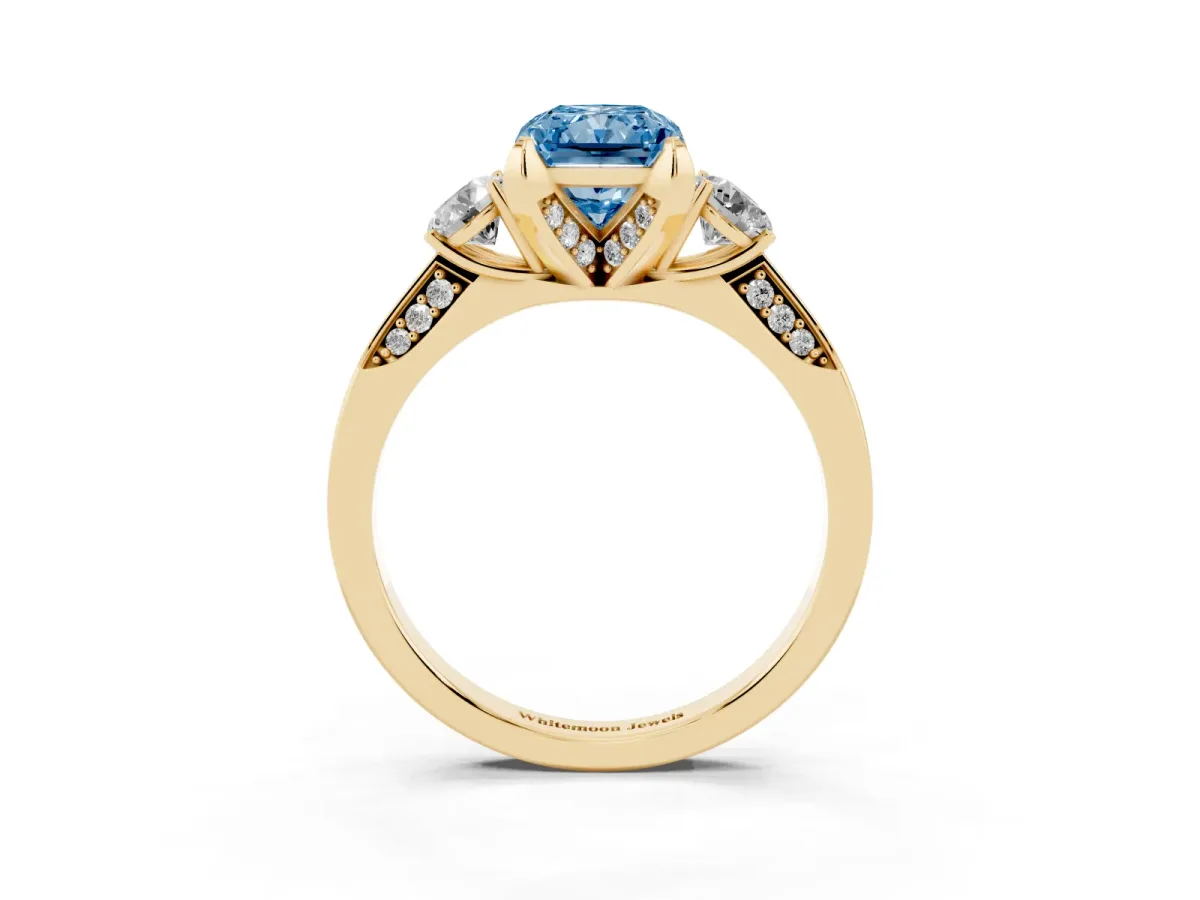 Fancy Blue Radiant Cut Brilliant Three-Stone Diamond Ring with Pavé Band and Four-Prong Setting Yellow gold