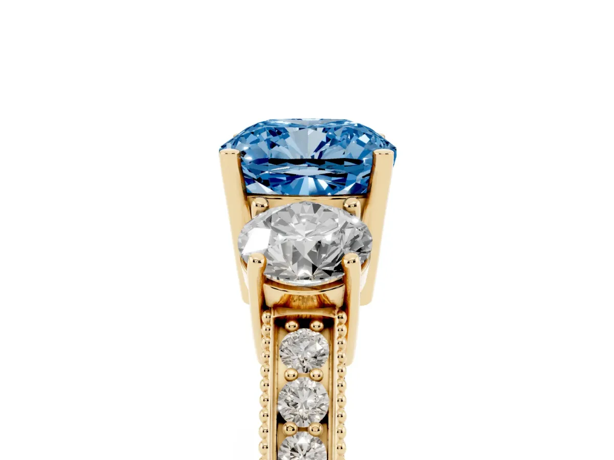 Fancy Blue Cushion Cut Three-Stone Diamond Ring with Pavé Band and Four-Prong Setting Yellow gold