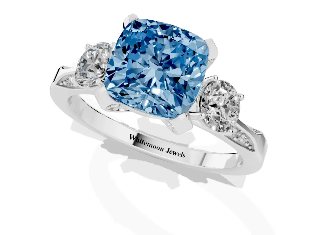 Fancy Blue Cushion Cut Brilliant Three-Stone Diamond Ring with Pavé Band and Four-Prong Setting White gold