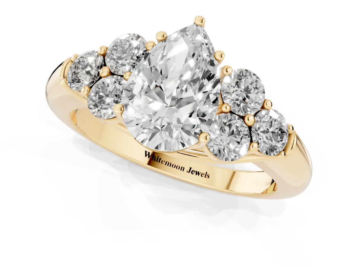 Pear Cut Cut Diamond Cluster Ring with Round Accent Stones and Prong Setting on a Classic Band Yellow gold