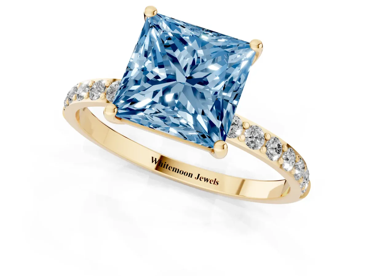 Fancy Blue Princess Cut Diamond Solitaire Ring with Round Pavé Shoulders and Prong Setting Yellow gold