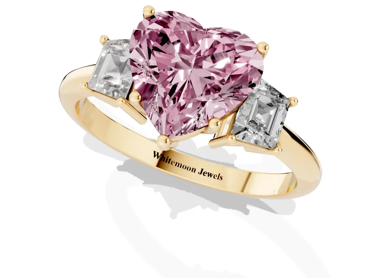 Fancy Pink Heart Cut Diamond Three-Stone Ring with Trapezoid Side Stones and Prong Setting Yellow gold