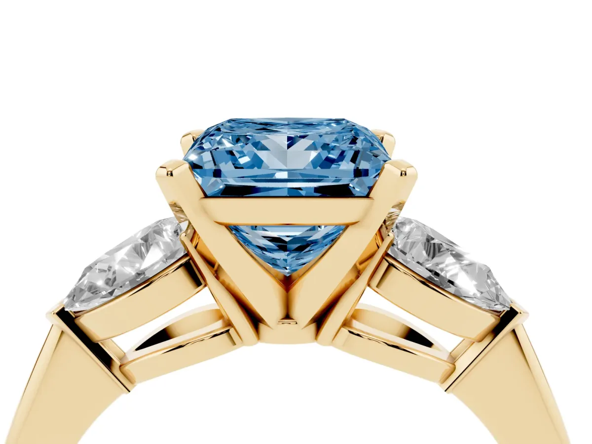 Fancy Blue Three-Stone Princess Cut Diamond Ring with Pear Side Stones and Four-Prong Setting Yellow gold