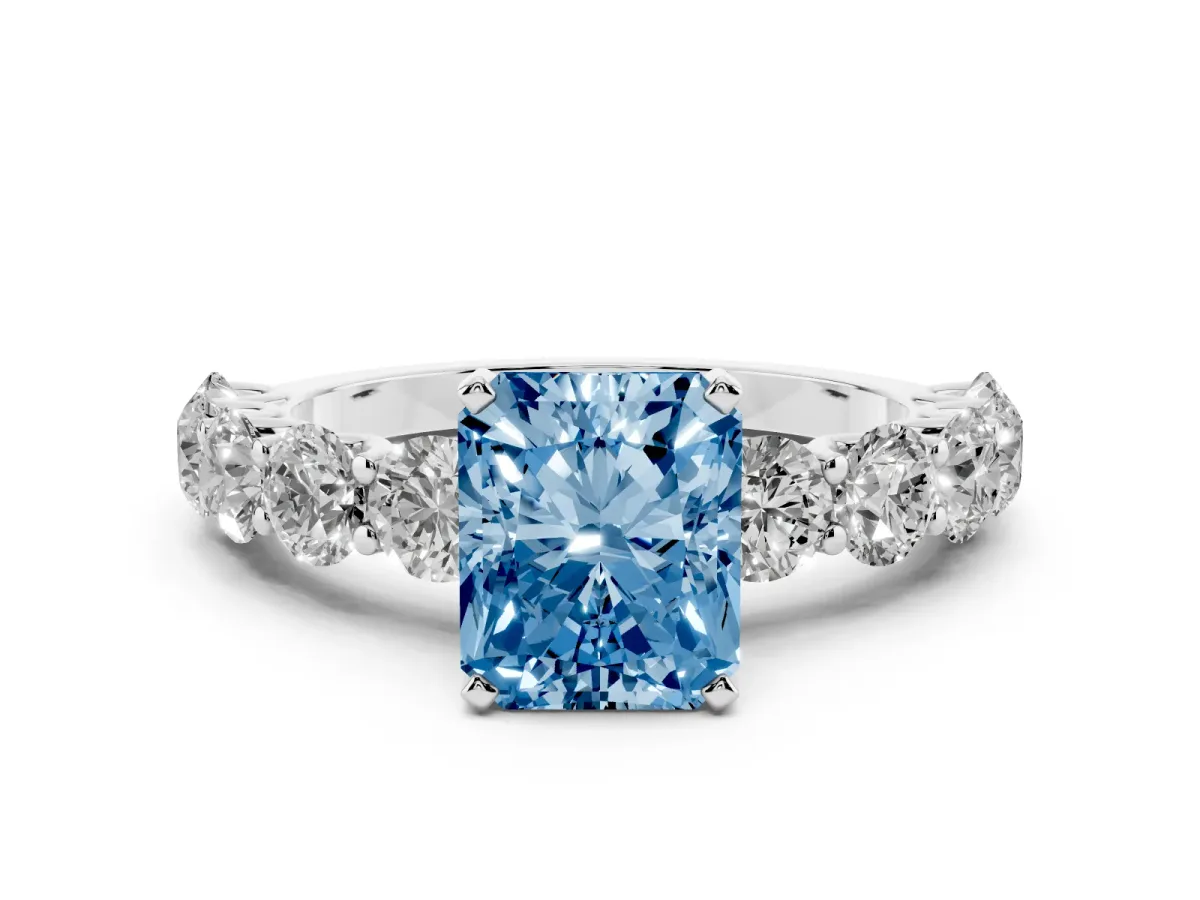 Fancy Blue Radiant Cut Diamond Prong Setting with Side Stones on a Pave Band Platinum