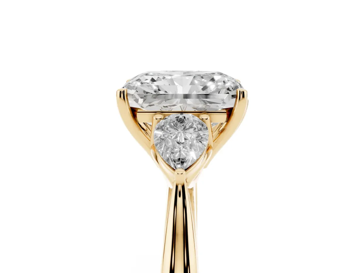 Three-Stone Radiant Cut Diamond Ring with Pear Side Stones in Four-Prong Setting Yellow gold