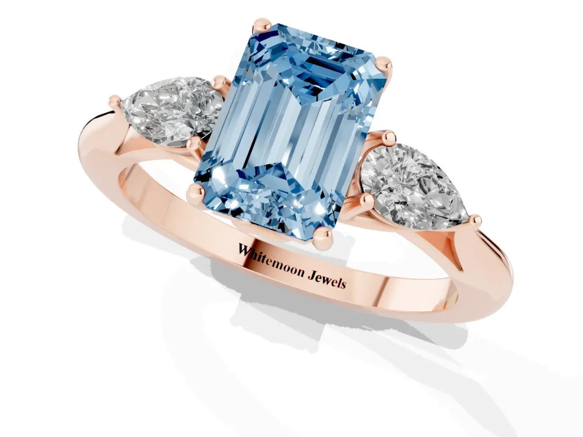Fancy Blue Three-Stone Emerald Cut Diamond Ring with Pear Side Stones in Four-Prong Setting Rose gold