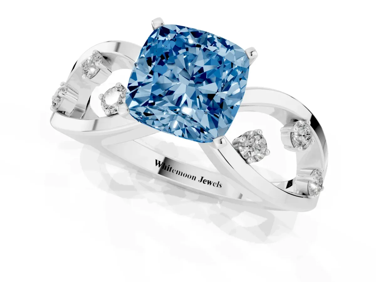 Fancy Blue Cushion Cut Cut Solitaire Diamond with Side Stones on Criss-Cross Band and Four-Prong Setting Silver