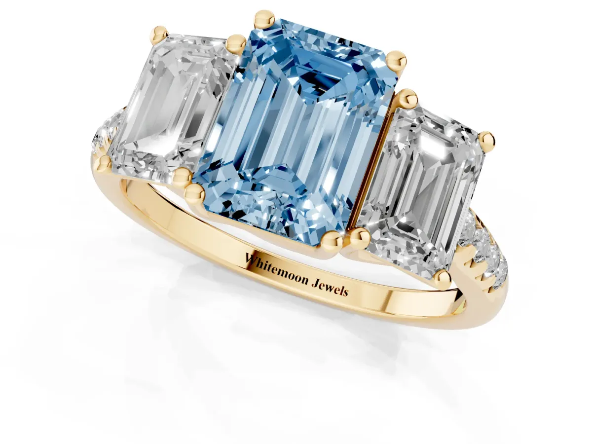 Fancy Blue Three-Stone Emerald Cut Diamond Ring with Round Pavé Band and Prong Setting Yellow gold