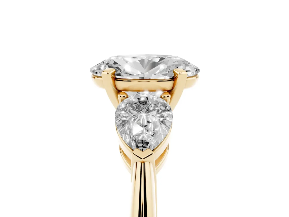 Three-Stone Oval Cut Diamond Ring with Pear Side Stones and Four-Prong Setting Yellow gold