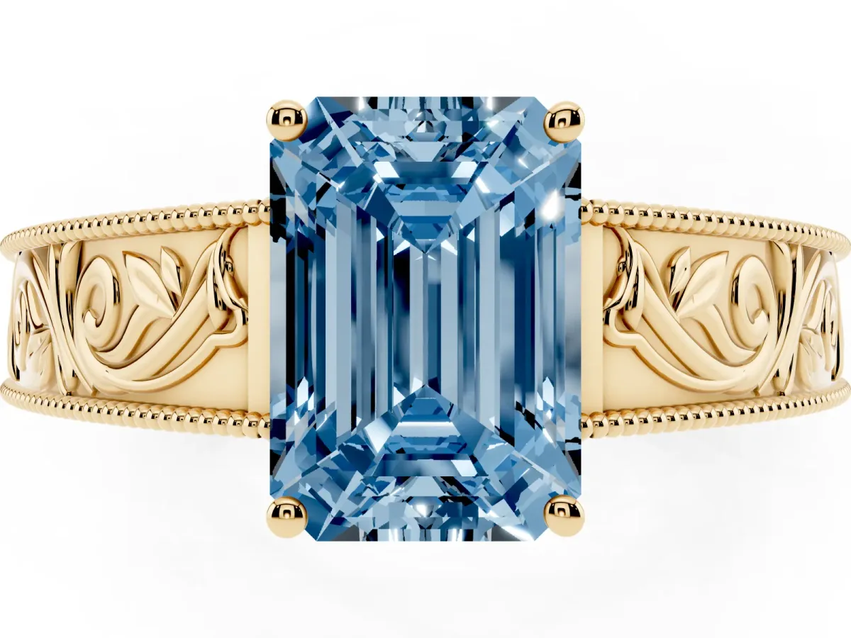 Fancy Blue Emerald Cut Diamond Solitaire Ring with Engraved Band and Four-Prong Setting Yellow gold