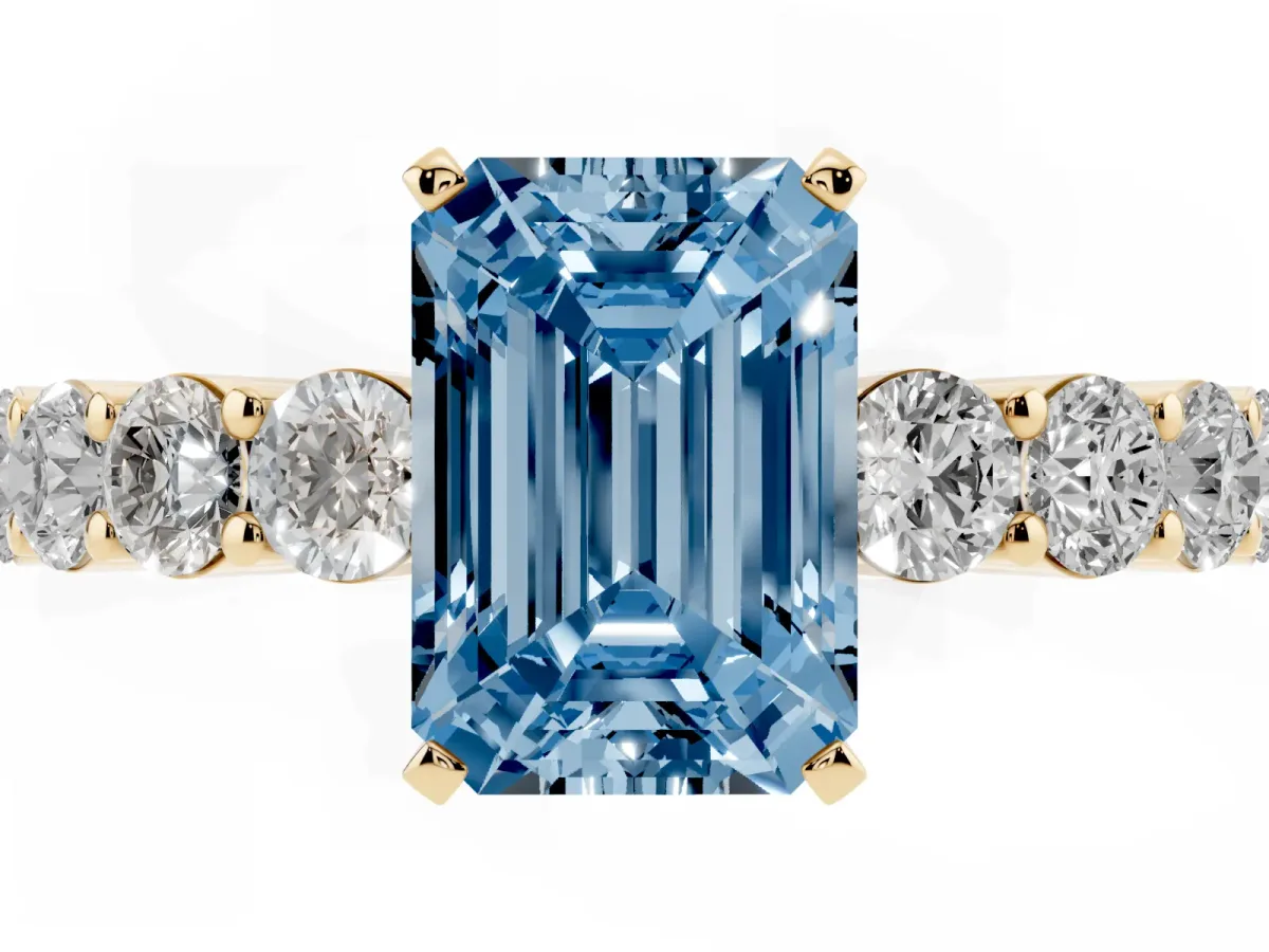 Fancy Blue Emerald Cut Diamond Solitaire Ring with Shared Prong Round Side Stones Yellow gold
