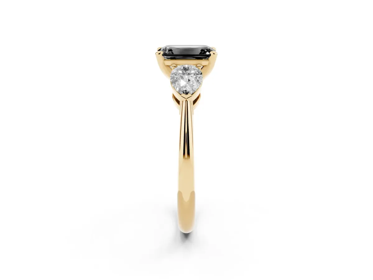 Fancy Black Three-Stone Emerald Cut Diamond Ring with Pear Side Stones and Four-Prong Setting Yellow gold