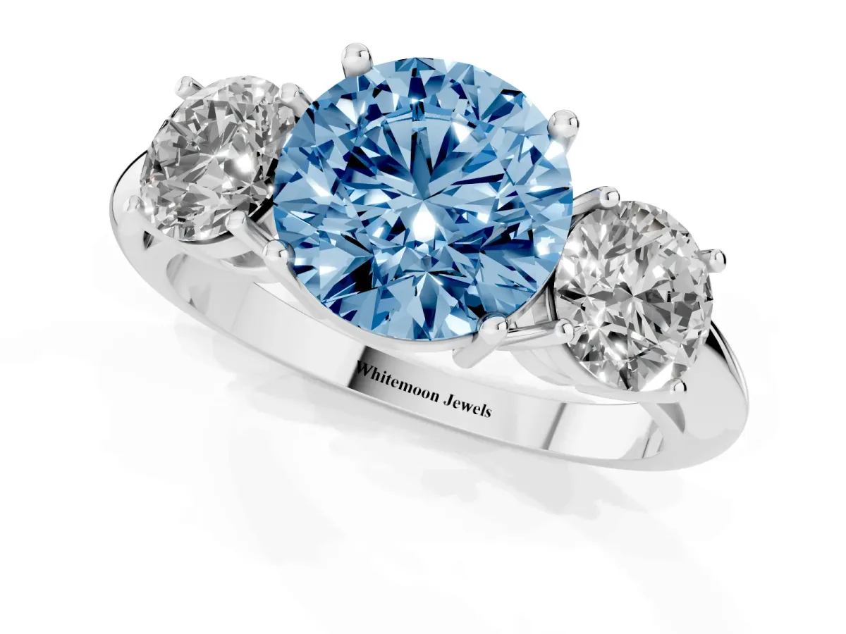 Fancy Blue Three-Stone Round Cut Cut Diamond Engagement Ring with Prong Setting on a White Gold Band Platinum