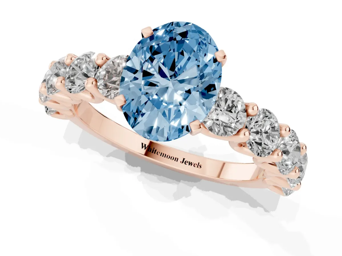 Fancy Blue Oval Cut Diamond Prong Setting with Side Stones on a Pave Band Rose gold