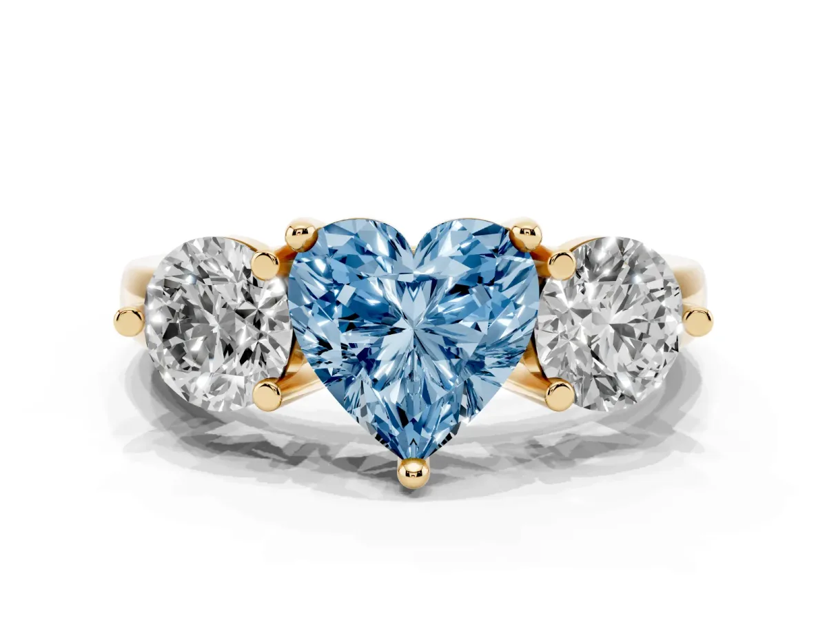 Fancy Blue Three-Stone Heart Cut Brilliant Cut Solitaire Ring with Prong Setting on a Classic Band Yellow gold
