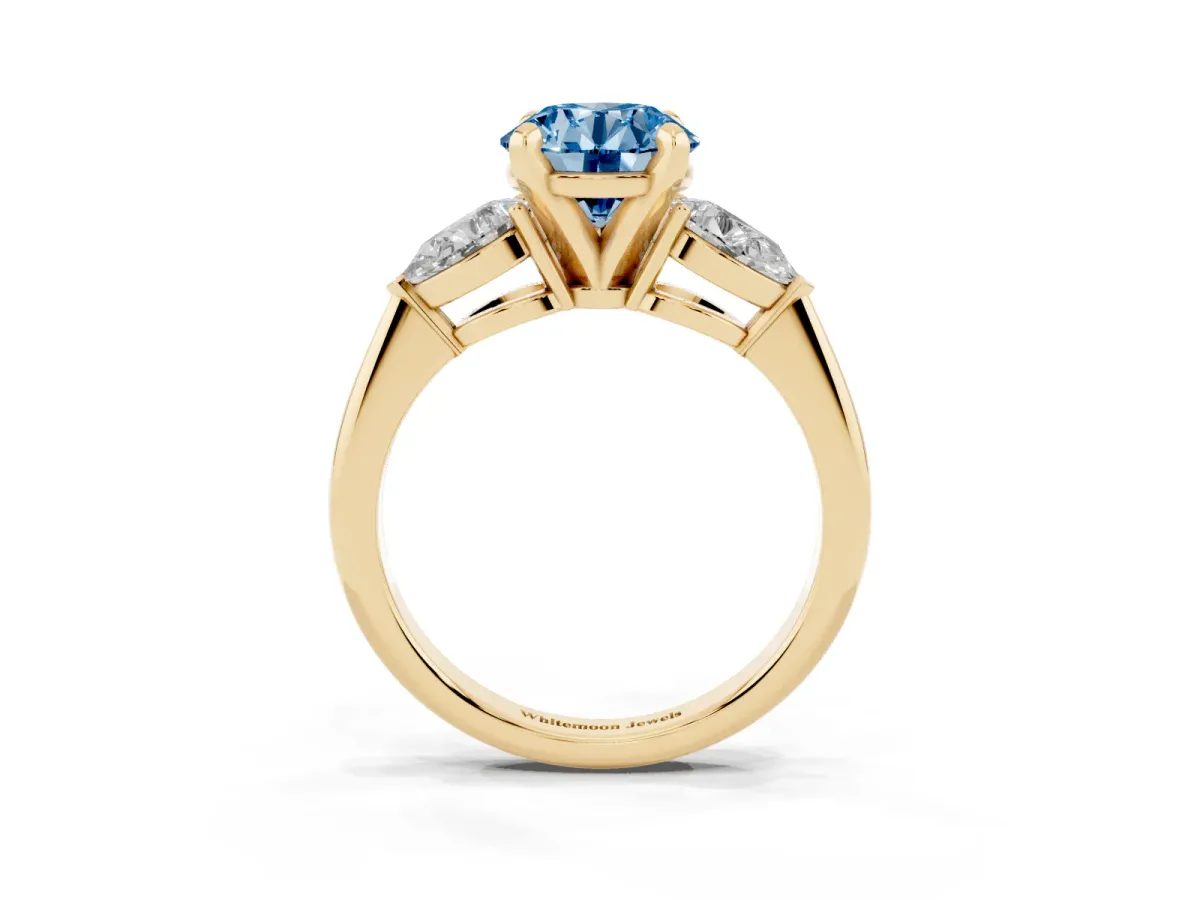 Fancy Blue Three-Stone Round Cut Diamond Ring with Pear Side Stones and Four-Prong Setting Yellow gold