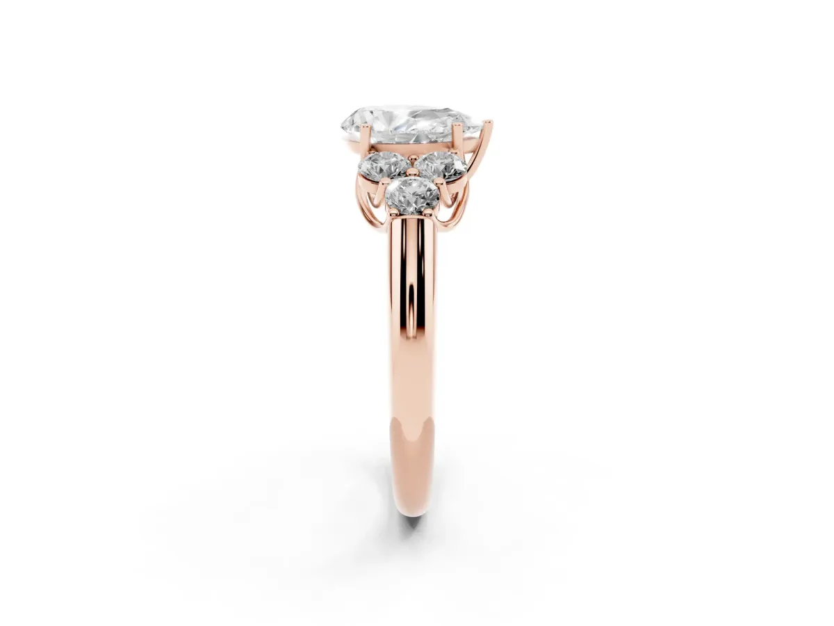 Pear Cut Cut Diamond Cluster Ring with Round Accent Stones and Prong Setting on a Classic Band Rose gold