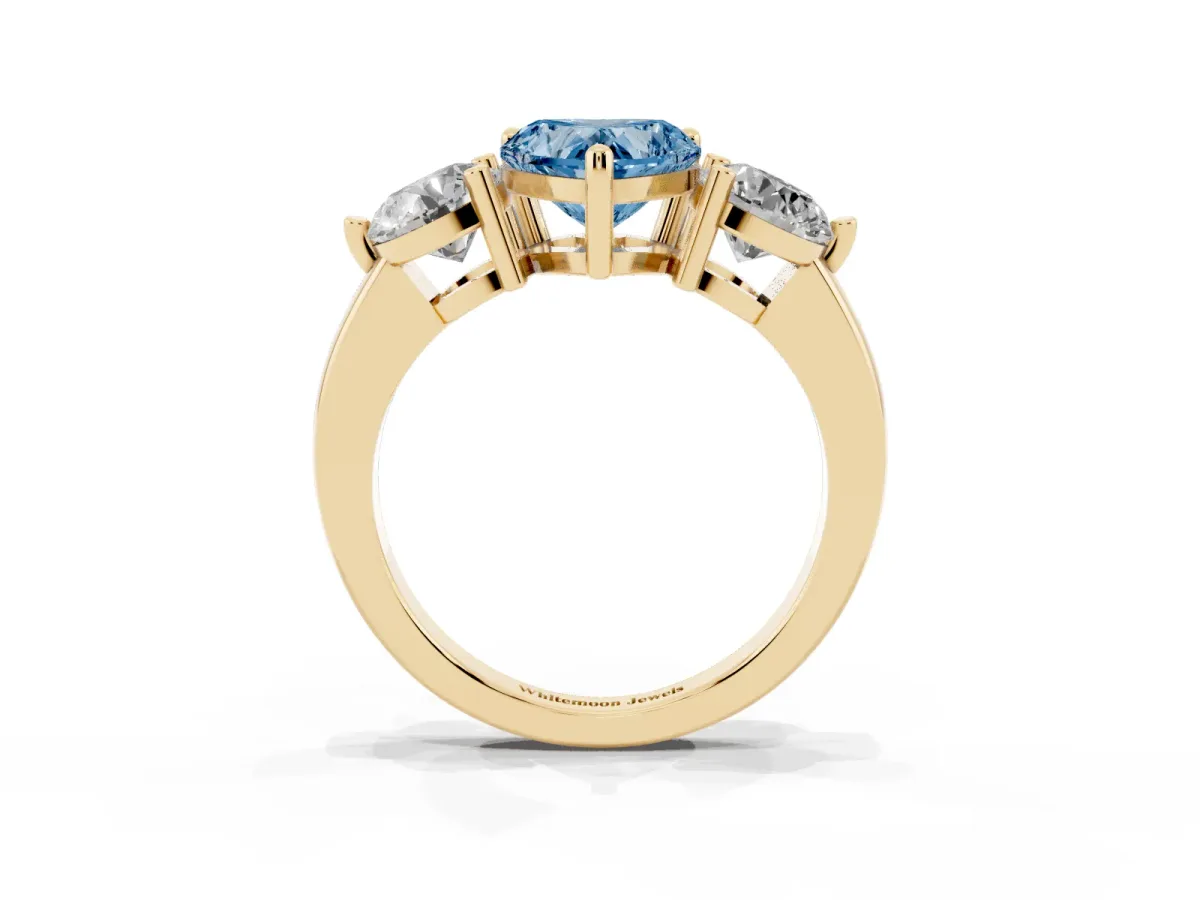 Fancy Blue Three-Stone Heart Cut Brilliant Cut Solitaire Ring with Prong Setting on a Classic Band Yellow gold