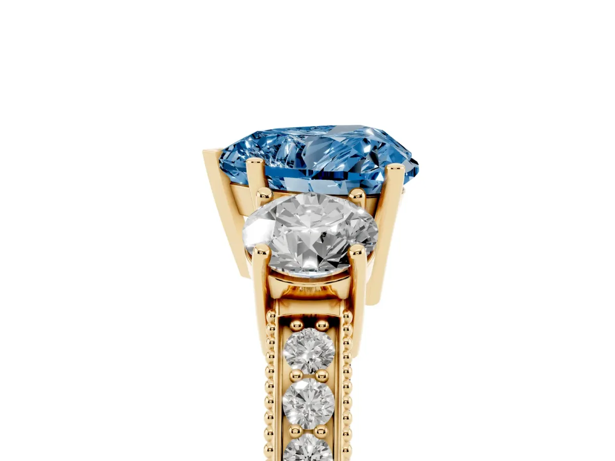 Fancy Blue Heart Cut Three-Stone Diamond Ring with Pavé Band and Four-Prong Setting Yellow gold