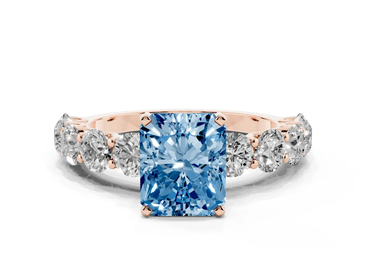 Fancy Blue Radiant Cut Diamond Prong Setting with Side Stones on a Pave Band Rose gold