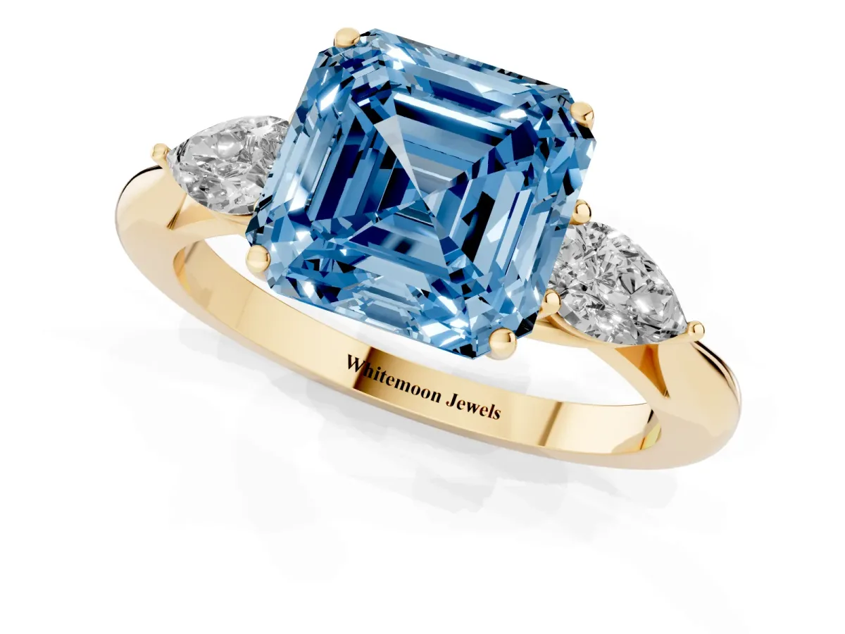 Fancy Blue Three-Stone Asscher Cut Diamond Ring with Pear Side Stones in Four-Prong Setting Yellow gold