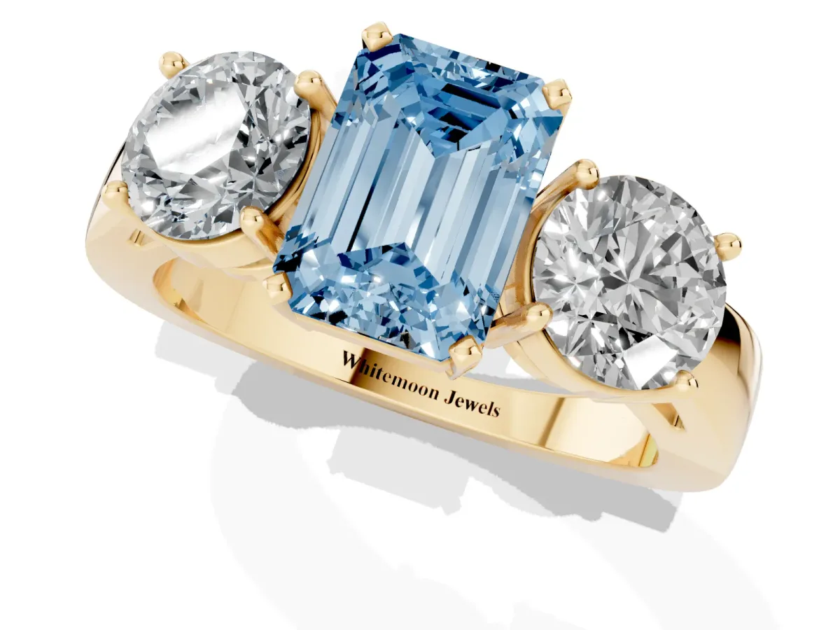 Fancy Blue Three-Stone Emerald Cut Diamond Ring with Round Side Stones, Classic Band, and Four-Prong Setting Yellow gold