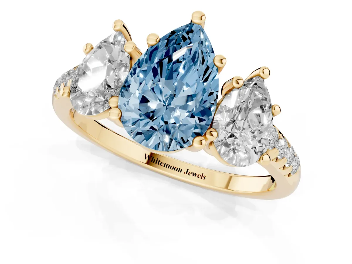 Fancy Blue Three-Stone Pear Cut Diamond Ring with Round Pavé Band and Prong Setting Yellow gold