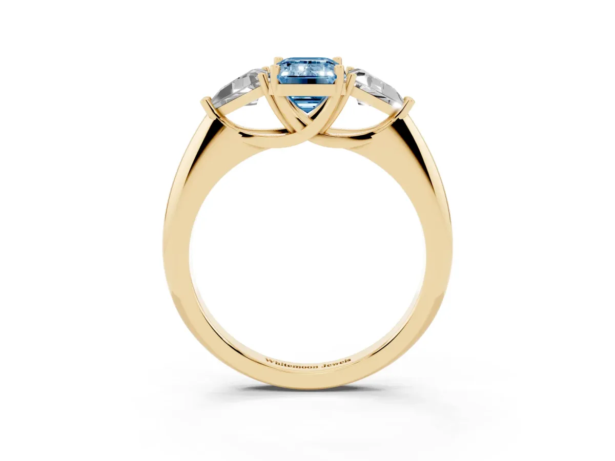 Fancy Blue Three-Stone Emerald Cut Diamond Engagement Ring with Trillion Side Stones and Prong Setting Yellow gold