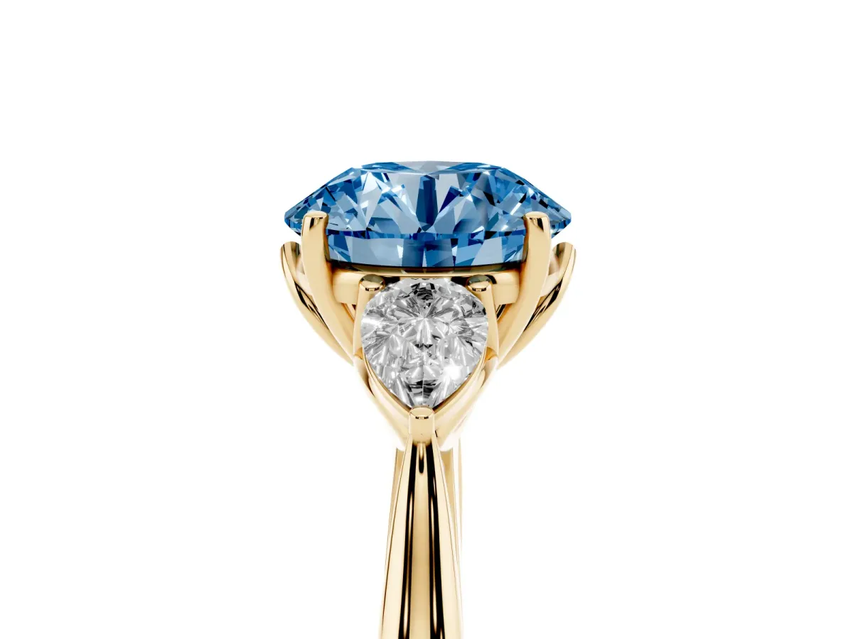 Fancy Blue Round Cut Diamond Three-Stone Ring with Pear Side Stones and Prong Setting Yellow gold