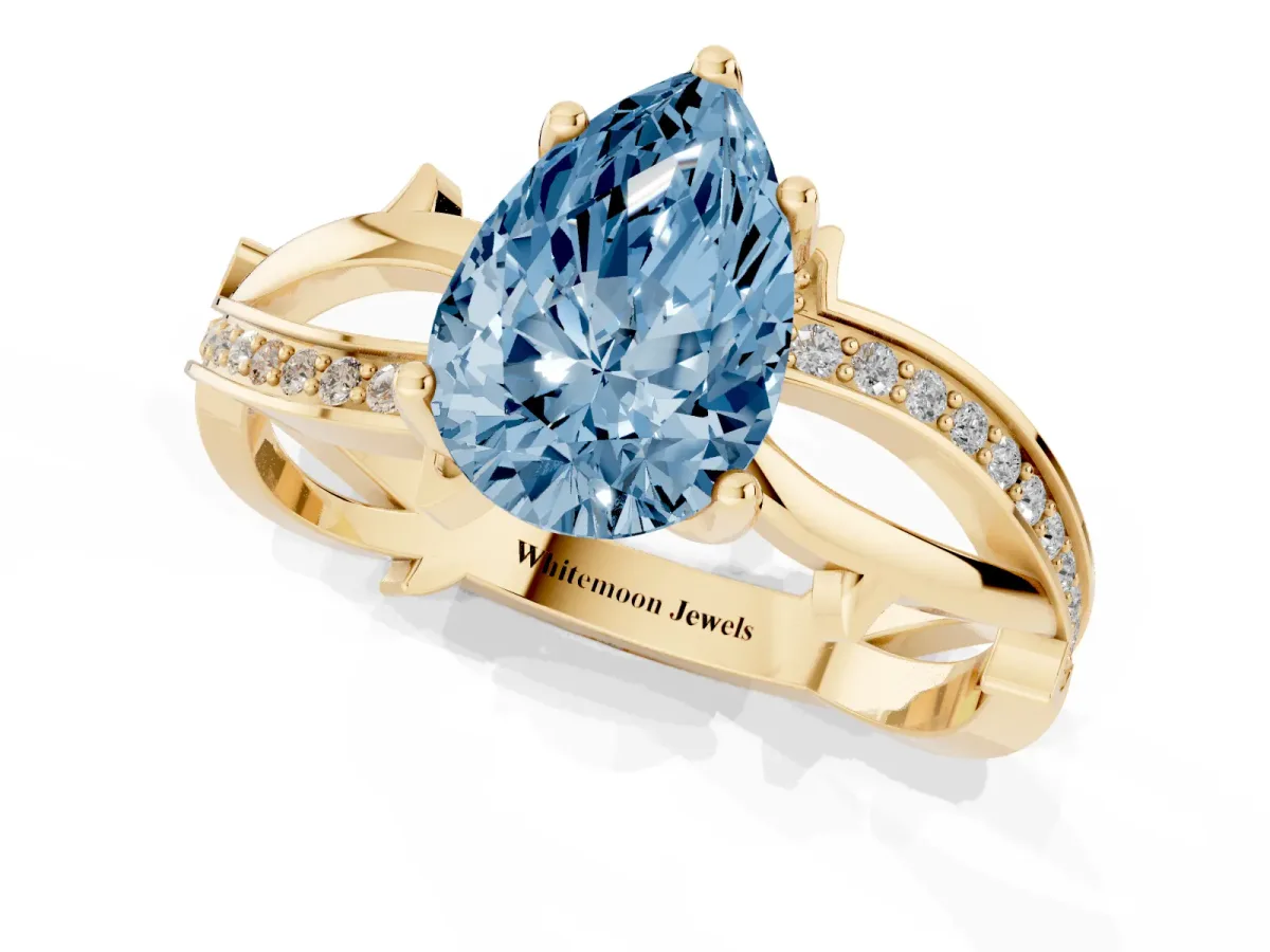 Fancy Blue Pear Cut Solitaire Twist Band with Pavé Accents and Four-Prong Setting Yellow gold