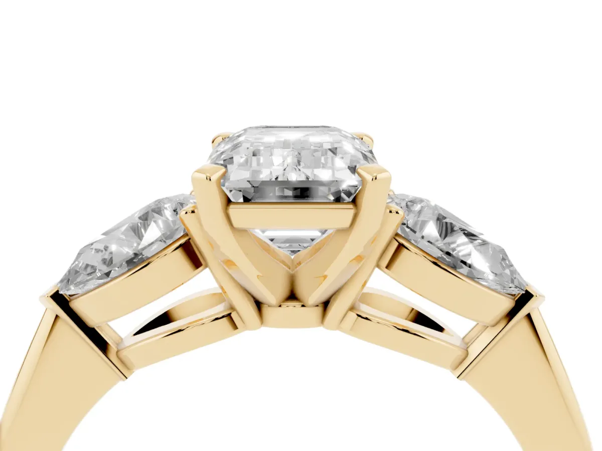 Three-Stone Emerald Cut Diamond Ring with Pear Side Stones and Four-Prong Setting Yellow gold